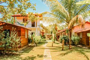 a courtyard of a house with palm trees and buildings at Family Guest House in Ilha de Boipeba