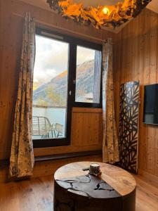 een kamer met een tafel en een groot raam bij Cocon au cœur de Chamonix avec parking gratuit in Chamonix-Mont-Blanc