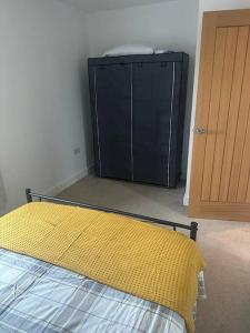 ein Schlafzimmer mit einem Bett und einem schwarzen Schrank in der Unterkunft Immaculate house in Doncaster in Cantley