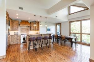 a kitchen with a bar and a table and chairs at Incredible 4BD Mtn Penthouse with Pool and Hot Tub, AC in Avon