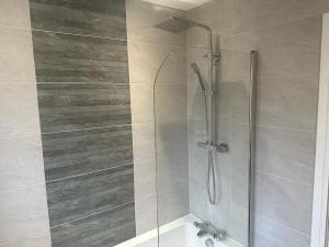 La salle de bains est pourvue d'une douche avec une porte en verre. dans l'établissement Immaculate house in Doncaster, à Cantley