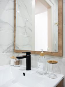 um lavatório de casa de banho com um dispensador de sabão e um espelho em Le Haut Cloquais - SereniStay em Metz
