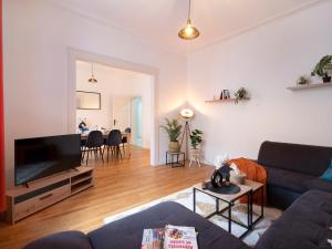 a living room with a couch and a flat screen tv at Le Haut Cloquais - SereniStay in Metz