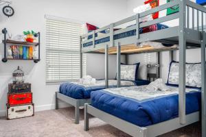 a bedroom with two bunk beds with blue sheets at New - Champions Gate 5-Bedroom in Davenport