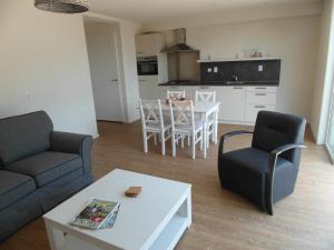 a living room with a couch and a table at het Neerland in Biggekerke