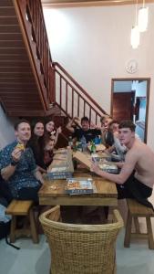 un grupo de personas sentadas en una mesa comiendo comida en Walur Surf Villa, en Krui