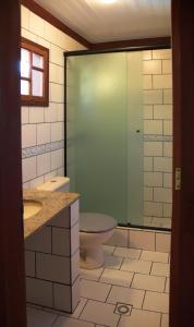 a bathroom with a toilet and a glass shower at Pousada Vistamar in Paraty