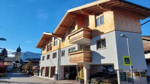 un edificio con balcones de madera en un lateral en FRANZ by Miha, en Westendorf