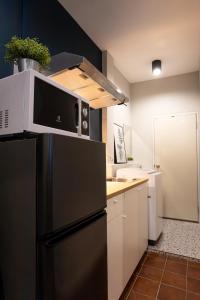 a kitchen with a black refrigerator and white cabinets at A4 Cosy Twin large beds - Silom in Bangkok
