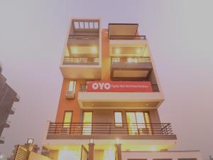 un edificio de apartamentos alto con un cartel. en Super OYO Flagship Comfort Residency Near Artemis Hospital, en Gurgaon