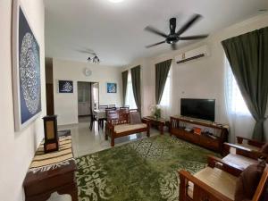 uma sala de estar cheia de mobiliário e uma televisão de ecrã plano em jm homestay semi d deluxe em Shah Alam