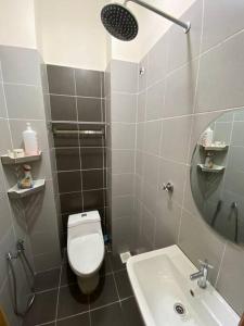 uma casa de banho com um WC, um lavatório e um espelho. em jm homestay semi d deluxe em Shah Alam