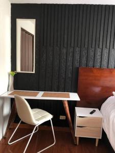 een slaapkamer met een bureau en een stoel naast een bed bij Apto confortable zona estratégica al Aeropuerto in Bogota