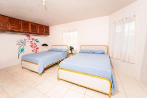 two beds in a room with white walls at Belle Air Seaview ( 2 Bdrm -2 Bath) in Runaway Bay