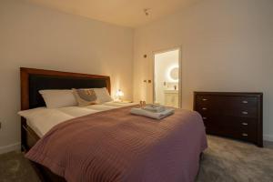 a bedroom with a bed and a dresser with a towel on it at H4-Free Parking-4BR-3BA-Sleeps8 