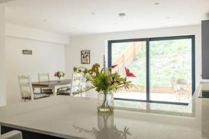 a kitchen with a table with a vase with flowers at H4-Free Parking-4BR-3BA-Sleeps8 