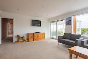 a living room with a couch and a table at Shalom - holiday home with panoramic views of the sea in Kingsdown