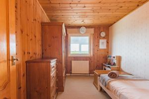 a small bedroom with a bed and a window at Shalom - holiday home with panoramic views of the sea in Kingsdown