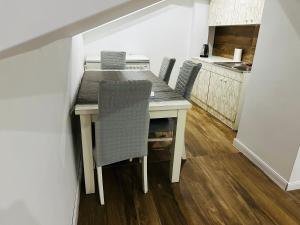 a dining room table with chairs and a kitchen at SA Apartment in Gjilan