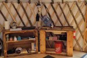 Ava Jade Yurt في Brownfield: غرفة مع رفوفين خشبية في يورت