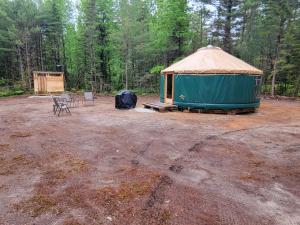 a yurt with a table and chairs in a field at Ava Jade Yurt in Brownfield