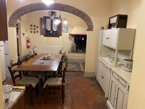 カスティリオーン・フィオレンティーノにあるAgriturismo Podere Delle Querciのキッチン、ダイニングルーム(テーブル、冷蔵庫付)