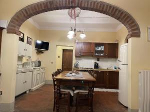 una cocina con una mesa de madera y un arco en Agriturismo Podere Delle Querci, en Castiglion Fiorentino