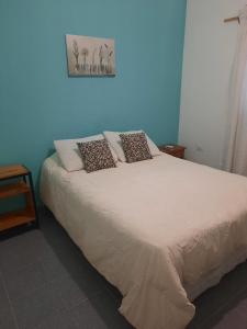 una cama con almohadas en una habitación en casa familiar confortable en Santiago del Estero