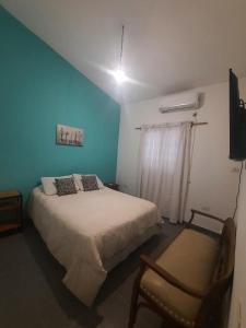 um quarto com uma cama grande e uma cadeira em casa familiar confortable em Santiago del Estero