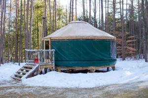 a gazebo in the snow in a forest at Rufus III Yurt on the river in Brownfield