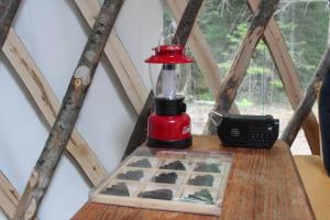 a red blender sitting on a wooden table with a box at Allie Mae Yurt nestled in the woods in Brownfield