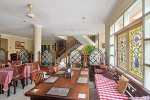a restaurant with wooden tables and chairs and stained glass windows at Puri Sawo Manila Residence in Jakarta