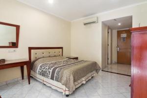 雅加達的住宿－Puri Sawo Manila Residence，一间卧室配有一张床、一张桌子和一面镜子