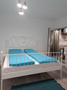een slaapkamer met een wit bed met blauwe kussens bij Апартамент Тюркоаз in Varna