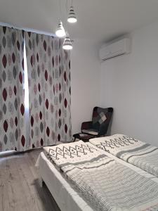 een slaapkamer met 2 aparte bedden en een stoel bij Апартамент Тюркоаз in Varna