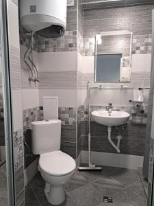 een badkamer met een toilet en een wastafel bij Апартамент Тюркоаз in Varna