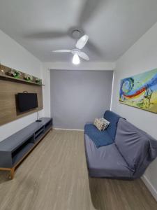 uma sala de estar com um sofá e uma televisão de ecrã plano em Apartamento Dona Elvira em Piçarras