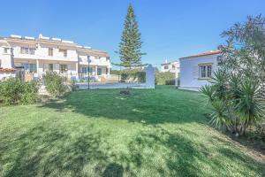 a yard with a house and a green lawn at VILLA BELA VISTA - BY BEDZY in Albufeira