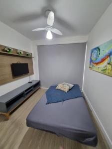 uma sala de estar com uma cama e uma televisão de ecrã plano em Apartamento Dona Elvira em Piçarras