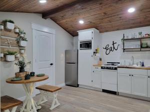 a kitchen with white appliances and a wooden ceiling at Little Blue Charming Lakefront in Canadian