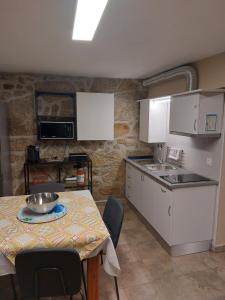- une petite cuisine avec une table et un comptoir dans l'établissement Casa das Cortes - Serra da Estrela, à Gouveia