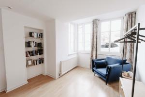 a living room with a blue chair and a window at Altstadt Apartment Lemgo in Lemgo