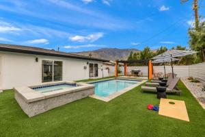 a backyard with a swimming pool and a house at NEW Sip Sip Away A Vibrant Pool and Hot Tub Retreat in Palm Springs