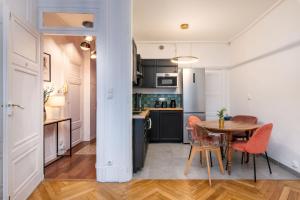 cocina y comedor con mesa y sillas en Le Cocon Savoir en Lyon