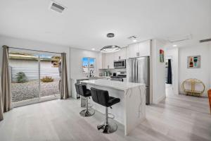 a kitchen with a counter and two bar stools at NEW Sip Sip Away A Vibrant Pool and Hot Tub Retreat in Palm Springs