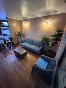 sala de estar con sofá azul y mesa en Cabaña Habitainer BordeRio 3 en Concepción