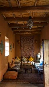 a room with many couches in a room at Kasbah Tigmi El Janoub in Aït Benhaddou