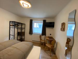 1 dormitorio con 1 cama, mesa y sillas en Haus Eder Steiner, en Saalbach Hinterglemm