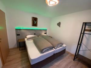 a bedroom with a bed with a green headboard at Haus Eder Steiner in Saalbach-Hinterglemm