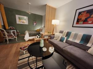 ein Wohnzimmer mit einem Sofa und einem Tisch in der Unterkunft Le domaine de Bachmay in Laval